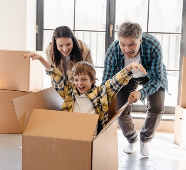 parents pushing a happy kid in a packing box
